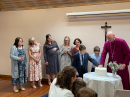 Bishop John Thomson helps to cut the cake